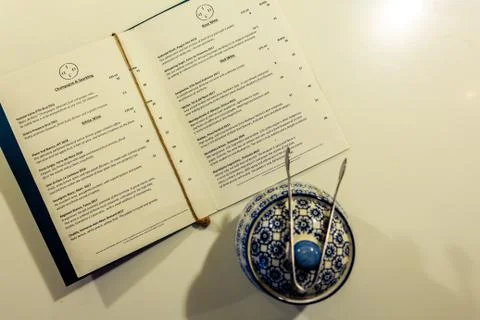 A top down picture of a restaurants menu and a tea pot Stock Photos