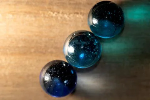 A top down portrait of three colored marbles casting a colored reflection ont Stock Photos