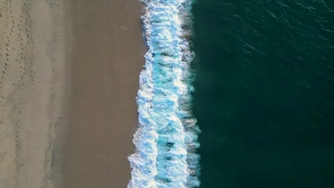 Top down right to left waves crashing on shore Stock Footage 256942539