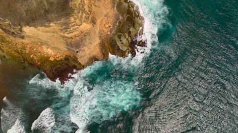 Top down rocky cliff edge with powerful surf exploding into white foam Stock Footage 336281048