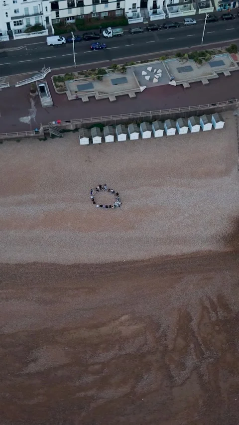Top-Down Rotating Aerial Shot Over Hastings Beach and Circle of People Stock Footage 342295313