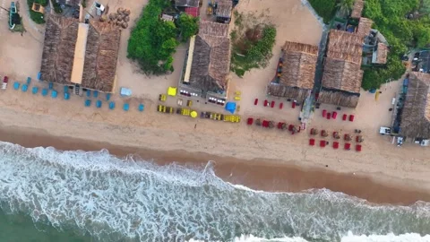 Top-down rotating aerial view of beach shacks and ocean waves in North Goa. Vídeo Stock 339550831