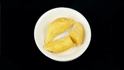Top-down rotating durian plate with golden flesh on black background. Stock Footage 335084272