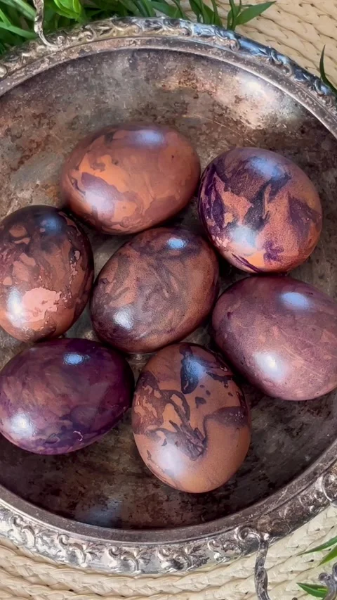 Top-down rotating view of naturally dyed Easter eggs in a vintage metal bowl Stock Footage 335923492