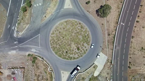Top down scenic 4k video aerial driving school car make a u-turn roundabout Stock Footage 175130249