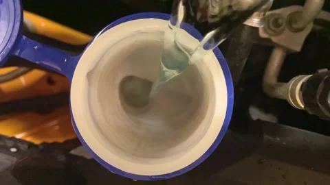 Top-down shot of the antifreeze being topped up in a cars engine bay 動画素材 229220305