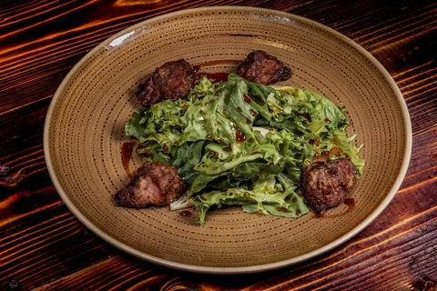 Top-down shot of an appetizing warm salad featuring green lettuce and crispy  Fotos de archivo