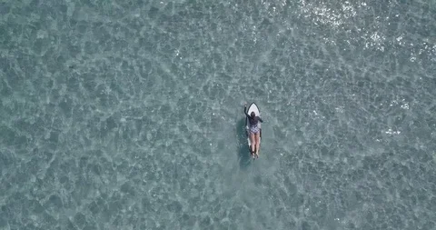 Top-down shot of attractive young woman on a surfboard Stock Footage 111773110