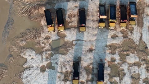 Top-down shot captures dump trucks moving on snow and mud 库存影片 341384272
