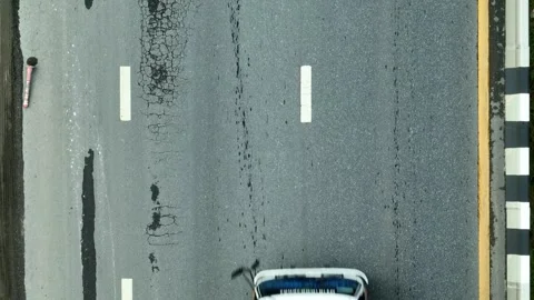 A top-down shot captures an road with visible cracks. Stock Footage 320594314