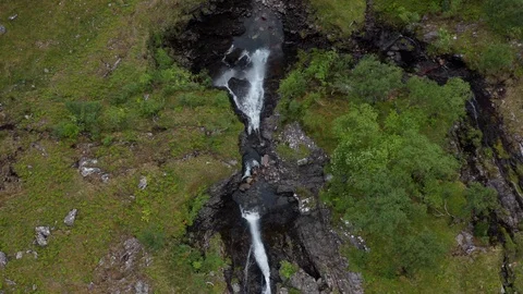 Top down shot of a cascading waterfall in Scotland green mountainside Stock Footage 116042149