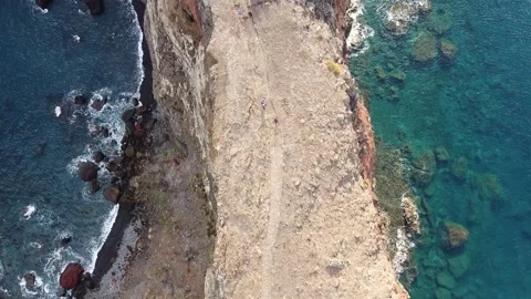 Top-down shot of Cliffs and Ocean with People walking. Stock Footage 192386332