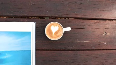 Top Down shot of coffee and surfing book Stock Footage 232917660