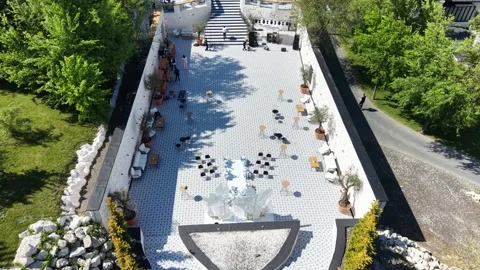 Top-down shot of contemporary terrace surrounded by lush trees and stone walls Vídeo Stock 336218422