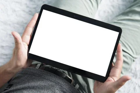 Top-down shot of digital tablet in young man's hands sititng comfortably on a Foto stock