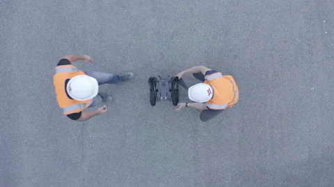 Top down shot of a DJI Matrice 300 RTK drone being setup by engineers Stock Footage 158668780