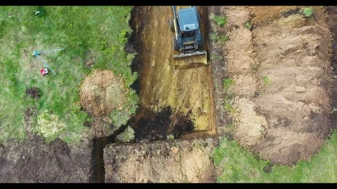 Top down shot of excavator digging foundation pit for new house Video stock 107655982