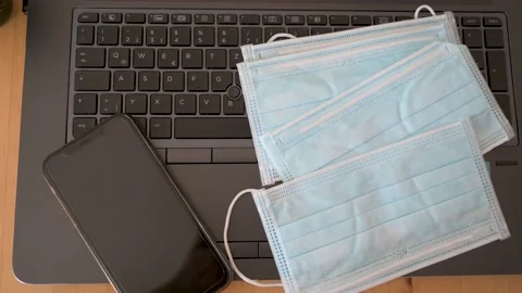 Top down shot of face masks to protect against Covid-19 on a laptop keyboard Stock Footage 132282270