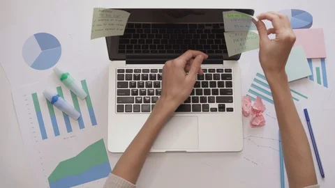 Top down shot of female getting the sticky notes off the laptop and crumple them Stock Footage 95620334