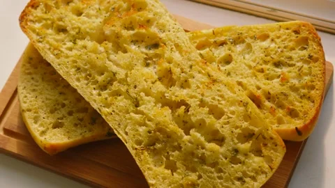 Top Down Shot of Freshly Baked Artisanal Garlic Herby Ciabatta Bread on Wooden Vidéo 336616510