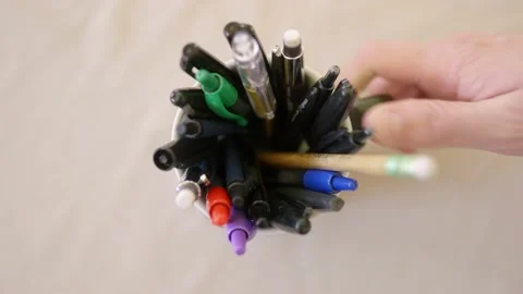 Top down shot of hand grabbing coffee mug of pens Stock Footage 142845547