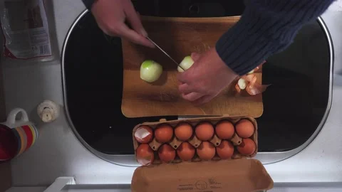 Top down shot of hands slicing onions on a wooden board in a small caravan Stock Footage 236499419