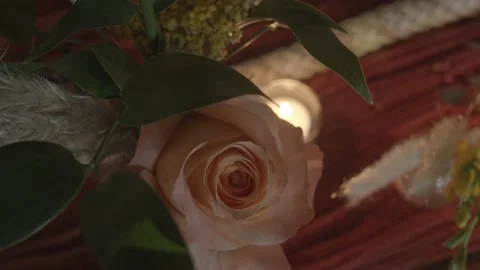 Top-down shot of a light pink rose and a tiny tea candle on a wedding Stock Footage 235774725