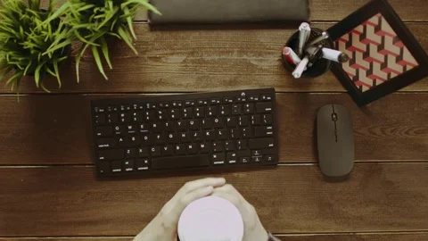 Top down shot of man with cup of coffee typing on keyboard Stock Footage 81165188
