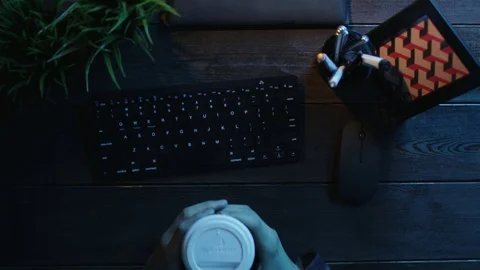 Top down shot of man with cup of tea typing on keyboard Stock Footage 81165237