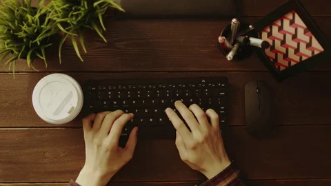 Top down shot of man drinking coffee while typing on keyboard Stock Footage 81165203