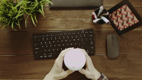 Top down shot of man drinking coffee and warming up his fingers before typing on Stock Footage 81165238