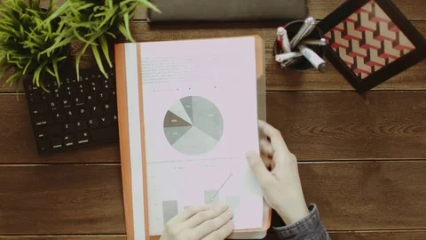 Top down shot of man looking for contract among papers with diagrams and graphs Stock Footage 81183628