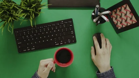 Top down shot of man scrolling mouse wheel and drinking coffee Stock Footage 81231920