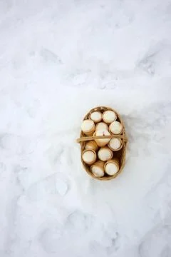 Top-down shot of mini ice cream cones in a basket in a snowy environment. Stock Photos