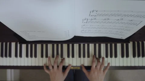 TOP DOWN SHOT OF PIANO PLAYING WITH MUSIC SHEET CHANGE OVER Stock Footage 126417502