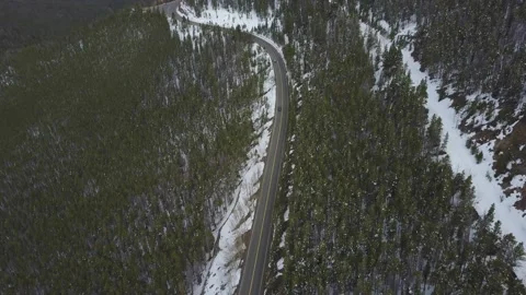 Top down shot of a remote road in a snowy mountainous forest Vídeos de archivo 167675788