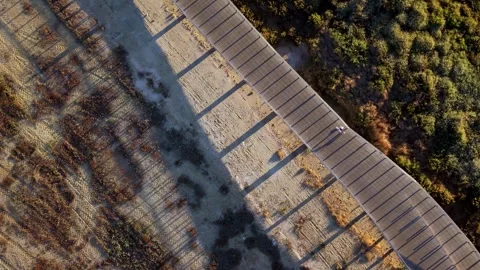 Top-down shot reveals bridge spanning rugged, earthy land Stock Footage 345226300