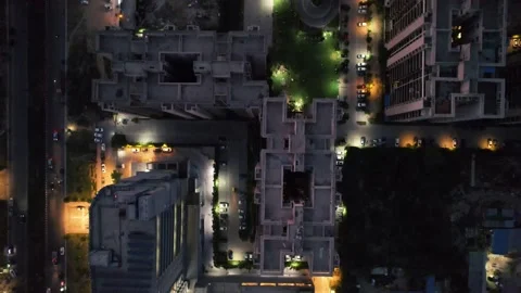 Top down shot showing vehicles moving around around skyscrapers with parks with Vidéo 197504643