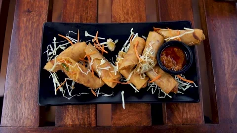 Top down shot of tasty spring roll plate on wooden table at fancy restaurant in  Stock Footage 318006598