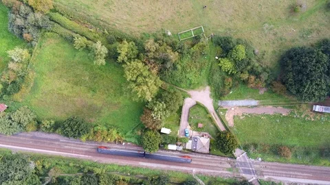 Top Down Shot of Train Passing Through Rural British Countryside 4K Drone Vídeo Stock 94865337