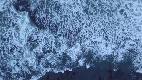 Top down shot of waves crashing on rocky beach Stock Footage 80841495