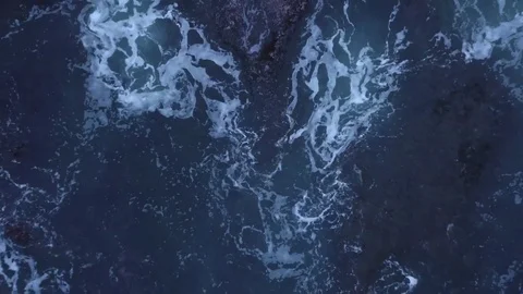 Top down shot of waves crashing on rocky beach Stock Footage 80842683