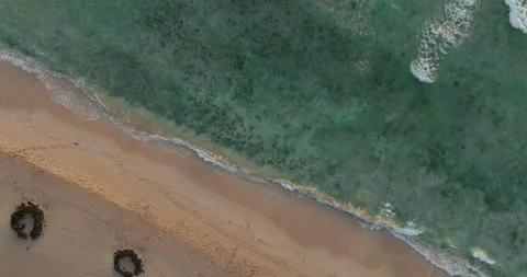 Top down shot of waves gently breaking on a sandy beach Stock Footage 343622040