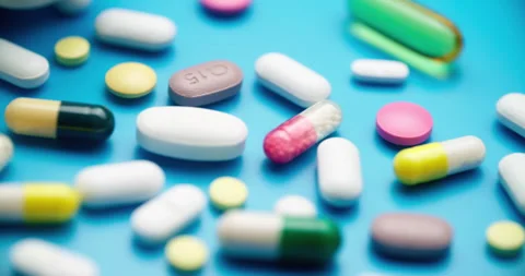 Top-Down Slide Motion of Colorful Pills on Blue Textured Surface Vídeo Stock 307994608