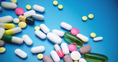Top-Down Slide Motion of Colorful Pills on Blue Textured Surface 動画素材 307996578