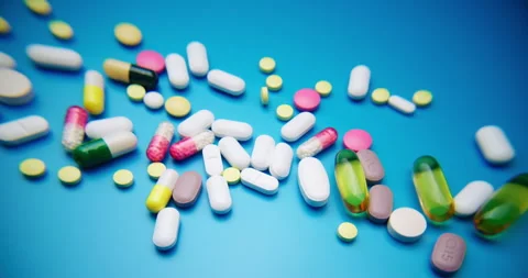 Top-Down Slide Motion of Colorful Pills on Blue Textured Surface 库存影片 307996710