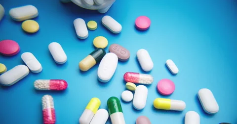 Top-Down Slide Motion of Colorful Pills on Blue Textured Surface Stock-Footage 308003930