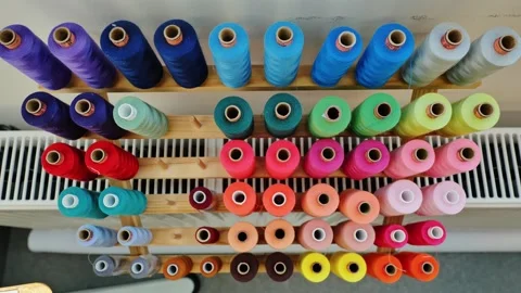 Top Down Slow Motion View of Colorful Thread Spools Arranged on Wooden Organizer Stock Footage 307406218
