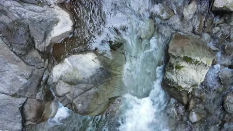 Top down slow motion water flowing over gorge stones Stock Footage 331900658