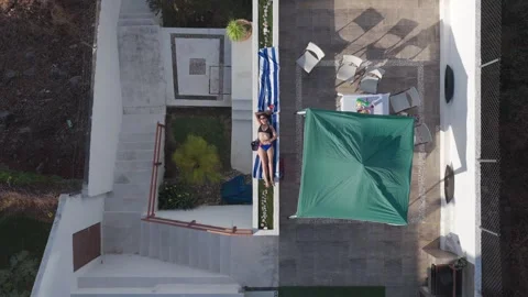 Top down static aerial shot of woman sunbathing Video stock 328263563